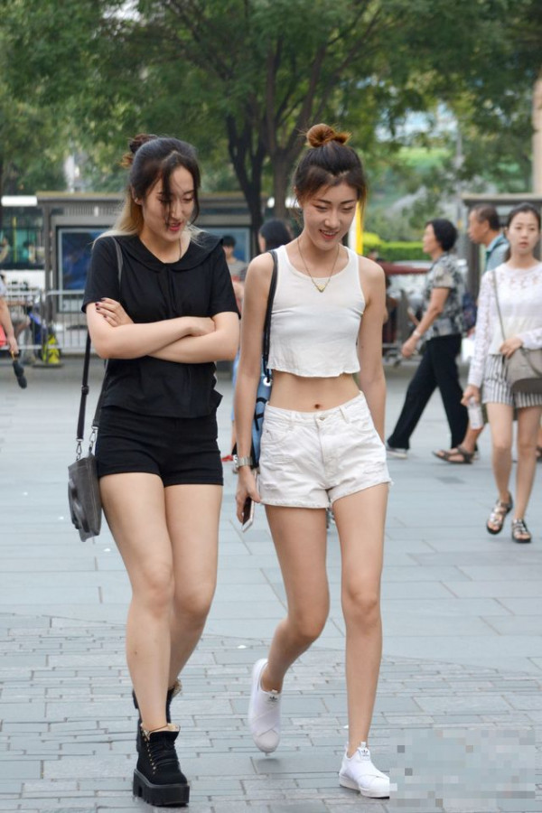 >街拍：黑白搭配的两位模特美女，白色衣服的露脐装更加凸显细腰