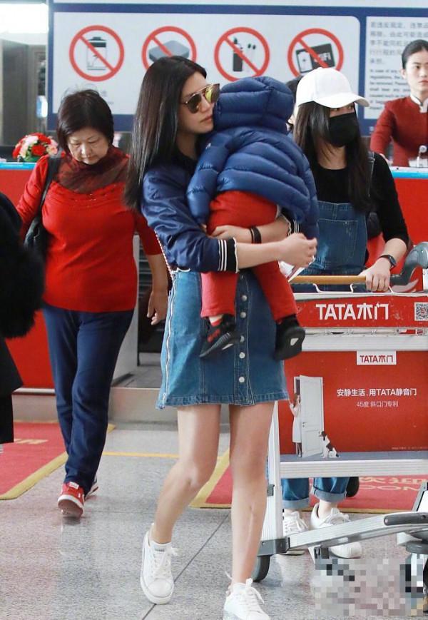 >陈妍希最新机场秀抱上了儿子小星星，两个人的打扮完全不同季节