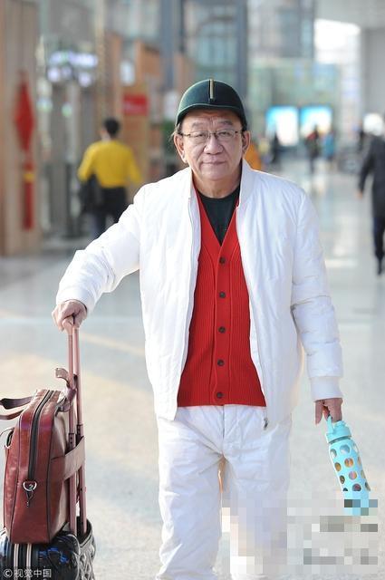 >72岁侯耀华现身机场，头戴绿帽穿红衣精神好
