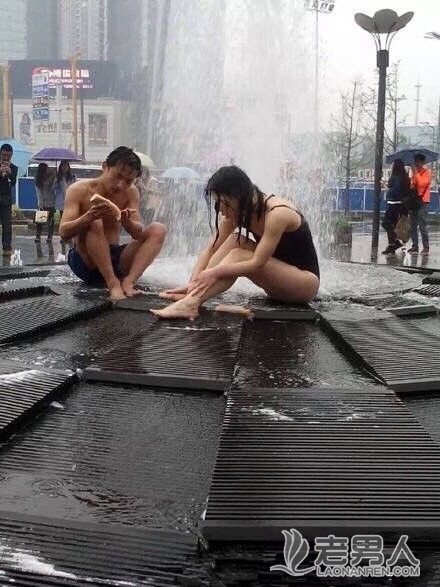 >男女坐广场喷泉出水口当众洗澡10分钟 还自带沐浴露(图)