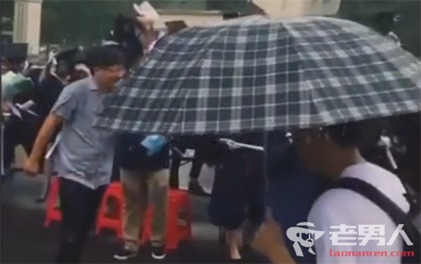 高校暴雨毕业照走红 雨中仍保持端坐微笑太敬业