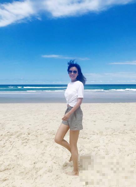 46岁闫妮沙滩享受日光浴 穿白色度假装秀好身材